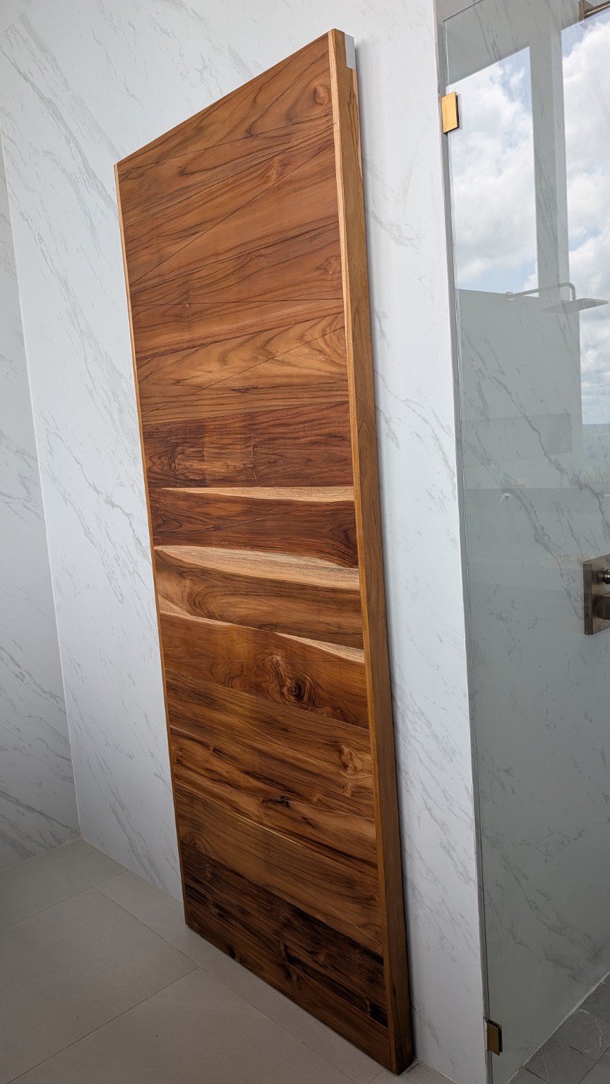 Puerta de madera junto a una ducha de vidrio